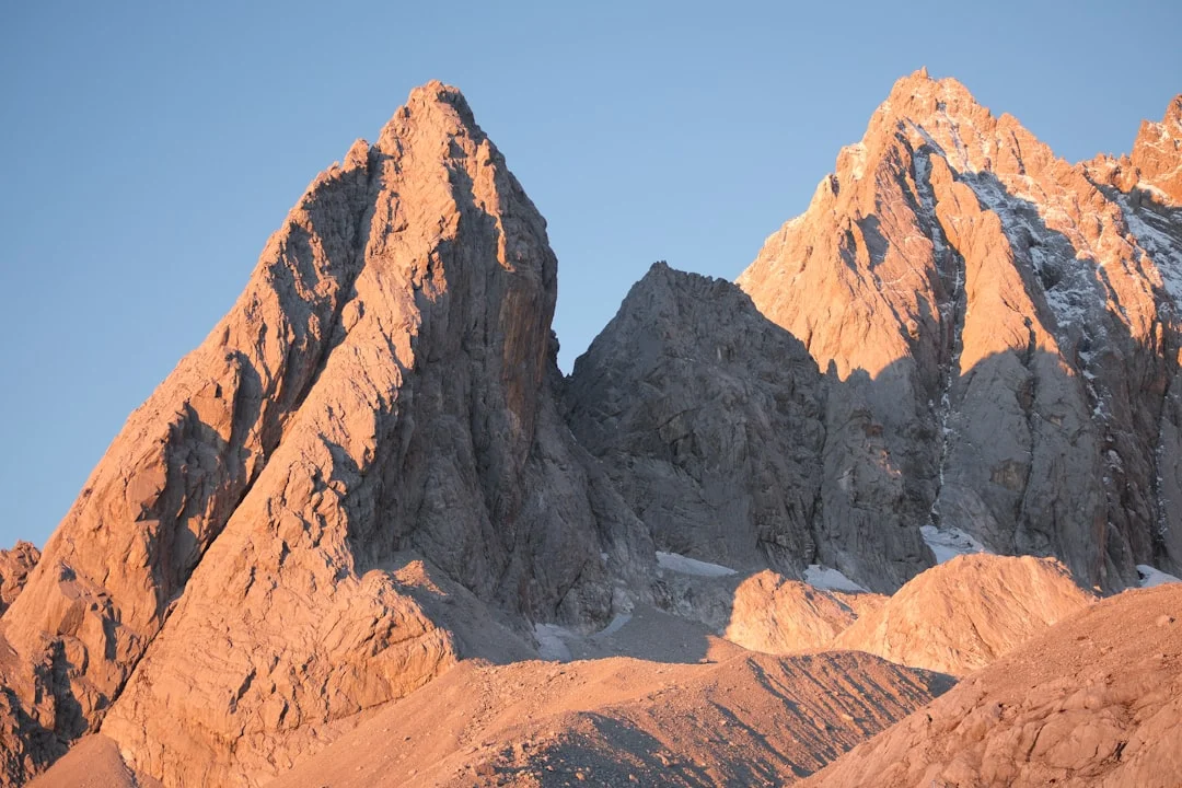 Jagged mountain peaks bathed in warm sunlight. — reaching peak performance