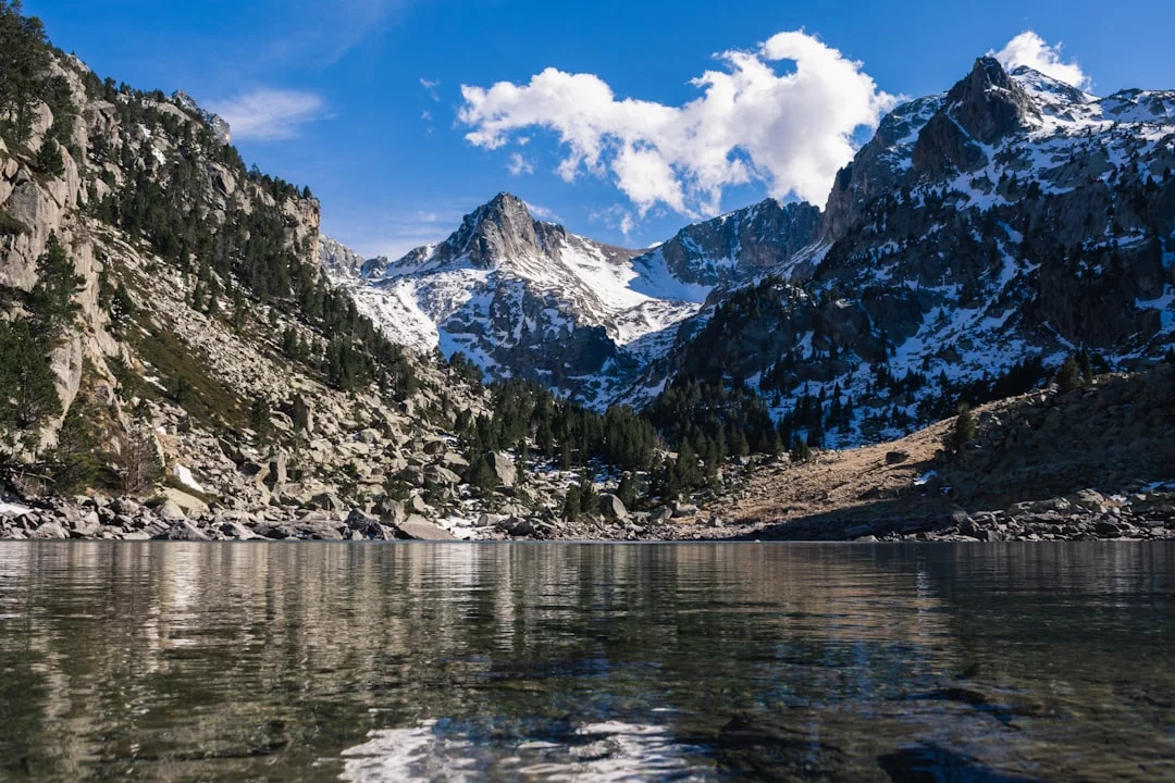 a mountain range is reflected in the still water of a lake — reaching peak performance