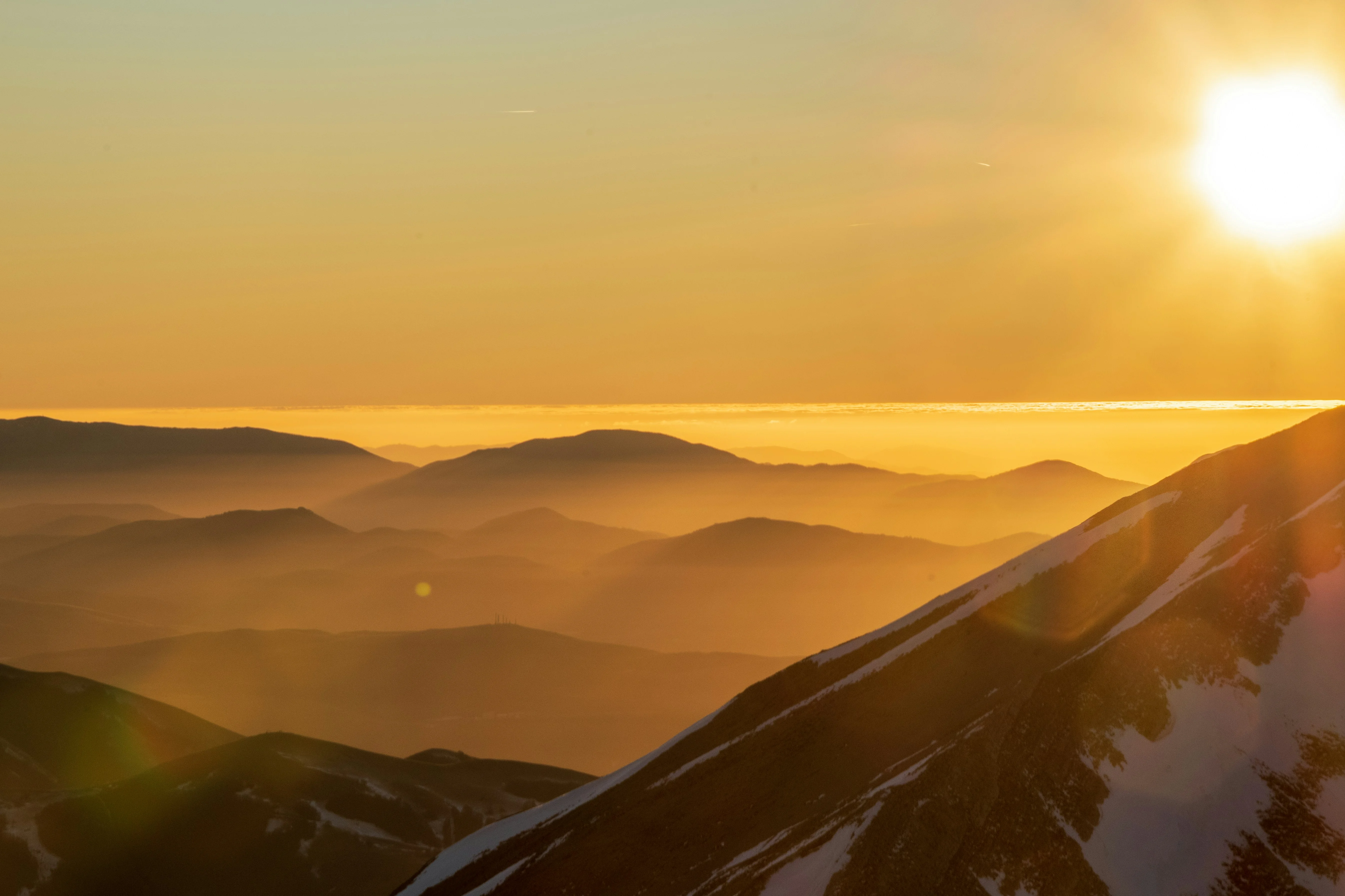 the sun is setting over a mountain range — reaching peak performance